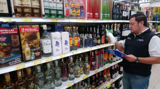 Un funcionario de Arcsa revisa bebidas alcohólicas, en un supermercado en Orellana, en 2019.