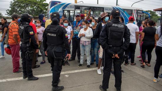 Policías refuerzas controles, mientras familiares de presos esperan información sobre sus seres queridos, en las afueras de la Penitenciaría del Litoral, en Guayaquil, el 13 de noviembre de 2021.