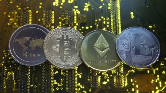 Representación de las criptomonedas Ripple, Bitcoin, Etherum y Litecoin sobre una placa.