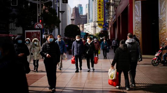 Ciudadanos caminan por una calle en el centro de Shangai, China, el viernes 21 de enero de 2022.