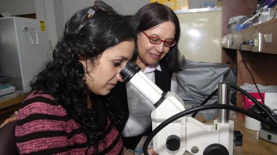 Eugenia del Pino junto a una estudiante de la PUCE en un laboratorio de Biología, en 2012.