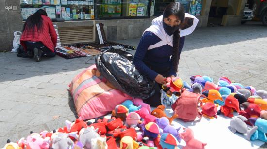 Una mujer vende juguetes en una calle de Cuenca, en diciembre de 2021. 