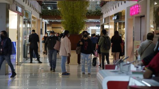 Personas caminan en un centro comercial en el centro norte de Quito, en diciembre de 2021. 