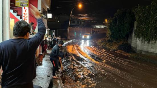 Habitantes de Sangolquí, en Rumiñahui, limpian las calles, tras el desbordamiento del río San Nicolás, el 11 de febrero de 2022.