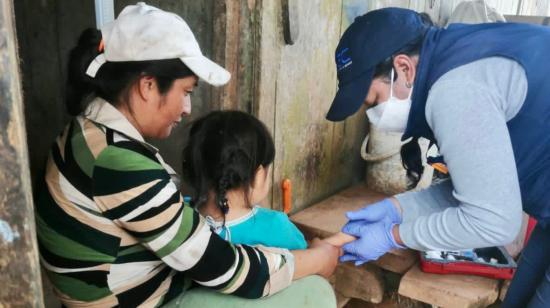 Un funcionario del INEC encuesta a una mujer sobre el estado de salud de su hijo, el 3 de marzo de 2022.