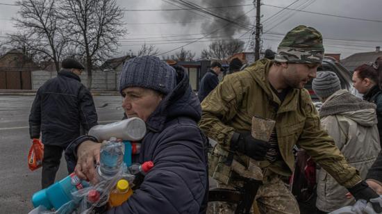 Una mujer recibe agua y productos de higiene, distribuidos por el Ejército ucraniano en la ciudad de Irpin, en la región de Kiev, el 3 de marzo de 2022.