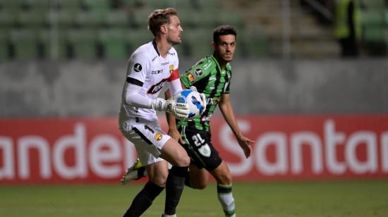 El portero de Barcelona Javier Burrai le gana una pelota a Lucas Kal de América Mineiro en el partido de ida de la Copa Libertadores de la Fase 3, el 8 de marzo de 2022.