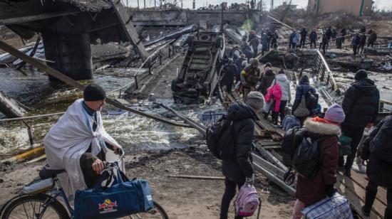 Personas cruzan un puente destruido en la ciudad de Irpin, en Ucrania, el 9 de marzo de 2022.