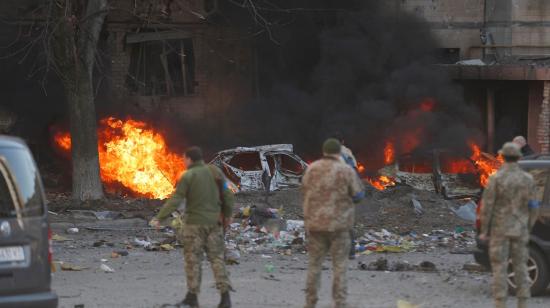 Militares y bomberos ucranianos frente a un edificio bombardeado por fuerzas rusas en Kyiv (Kiev), el 20 de marzo de 2022.