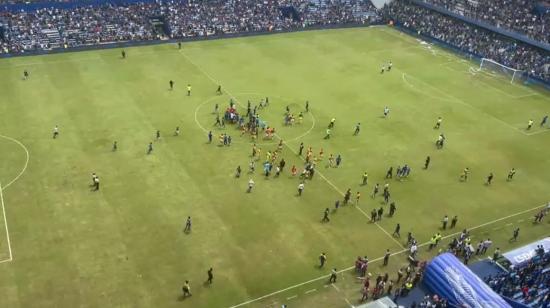 Hinchas de Emelec invaden la cancha del George Capwell, el lunes 21 de marzo de 2022.