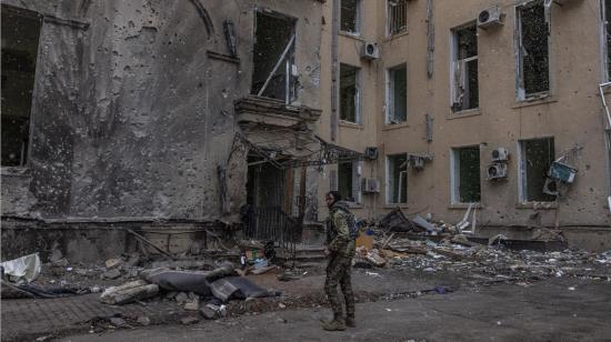 Un miembro del ejército ucraniano se encuentra junto al edificio dañado de la Administración Estatal Regional de Kharkiv, que fue fuertemente bombardeado por las fuerzas rusas, en Kharkiv, noreste de Ucrania, el 27 de marzo de 2022.