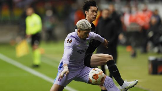 Daichi Kamada de Frankfurt disputa un balón con Ronald Araujo del FC Barcelona durante los cuartos de final de la Europa League, el 7 de abril de 2022.