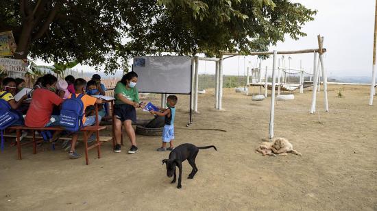 Denisse Toala (2nd R), una estudiante de 16 años, enseña a los niños en una escuela improvisada debajo de un árbol, ya que no pudieron asistir a clases virtuales en el barrio de bajos ingresos Realidad de Dios. 02/07/2020