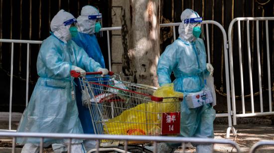 Personas con equipo de protección caminan por las calles de Shangái, en China, el 18 de abril de 2022.