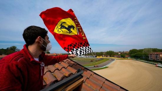 Imagen de un aficionado con la bandera de Ferrari al borde del Autódromo Enzo e Dino Ferrari, sede del GP de Imola.
