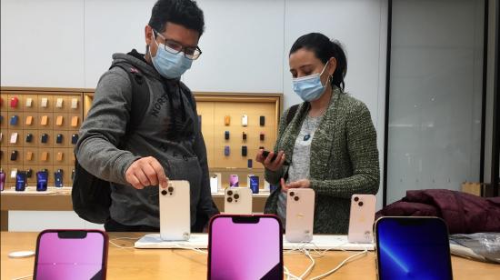 Dos personas mirando nuevos teléfonos de Apple en una tienda de Canadá, el 30 de marzo de 2022.