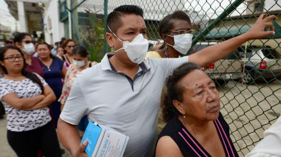 Ciudadanos hacen filas en los exteriores de una farmacia para comprar mascarillas, el 1 de marzo de 2020, en el centro de Guayaquil.