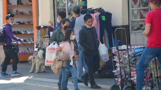 Personas caminan en una calle comercial de Cuenca, en diciembre de 2021.