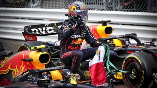 El piloto de Red Bull, 'Checo' Pérez, celebra su victoria del GP de Mónaco sobre su monoplaza y con la bandera de México, el domingo 29 de mayo de 2022.