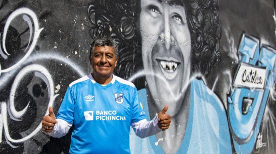 Antonio Arias posa junto al mural que pintaron sus hijos en el barrio El Calzado, en el sur de Quito.