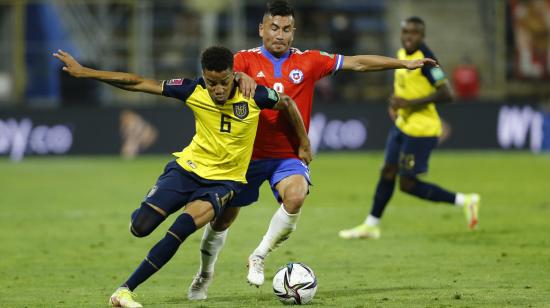 El jugador Byron Castillo de Ecuador pelea una pelota con Jean Meneses de Chile, el 16 de noviembre de 2021, en un partido de las Eliminatorias al Mundial de Catar 2022. 