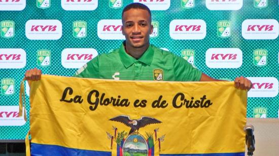 Byron Castillo sostiene una bandera de Ecuador en una rueda de prensa en México, el jueves 16 de junio de 2022.