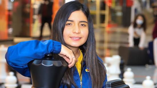 Anahí Ortiz posa junto a las piezas del tablero gigante de ajedrez, en un centro comercial de Quito, el 10 de noviembre de 2021. 