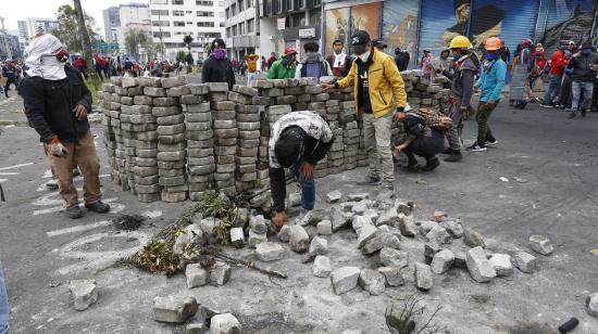 Manifestantes sacan parte del pavimento para armar una barricada, en una de las calles cercanas a la Casa de la Cultura, el 24 de junio de 2022. 