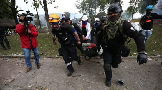 Paramédicos cargan a un herido durante los enfrentamientos con la Policía, este 24 de junio de 2022.