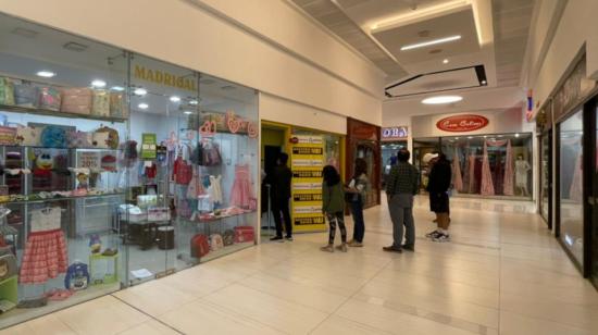 Personas forman una fila en el exterior de un local para enviar y recibir dinero, en el norte de Quito, el 6 de julio de 2022.