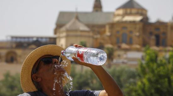 Un turista bebe agua ante la Mezquita-Catedral de Córdoba, en España, el 16 de julio de 2022. 