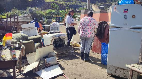 Dos moradoras del barro Santa Clara del Común en medio de electrodomésticos dañados, el 1 de agosto de 2022.