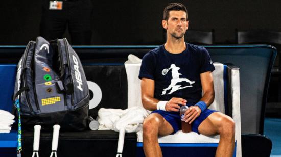 El tenista serbio Novak Djokovic descansa durante un entrenamiento para participar en el Abierto de Australia en el Melbourne Park, el viernes 14 de enero de 2022.