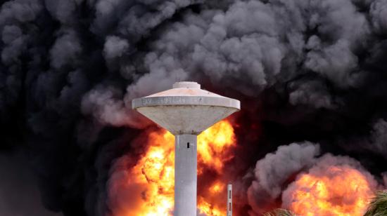 Un tanque para el almacenamiento de agua quedó envuelto en una columna de humo, generada por el incendio en un depósito de combustible en Matanzas, Cuba, el 7 de agosto de 2022.