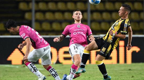 El defensa de IDV, Mateo Carabajal (centro), disputa un balón en el partido ante Táchira, en Venezuela, el 2 de agosto de 2022.