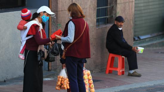 Una vendedora informal comercializa frutas en una calle de Quito, en julio de 2022.