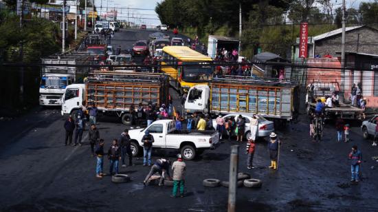 Vehículos y persona bloquean una calle en Quito, en junio de 2022.