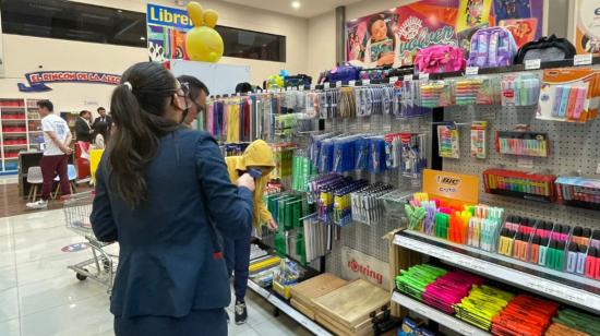 Una familia compra útiles escolares en el norte de Quito, en agosto de 2022.