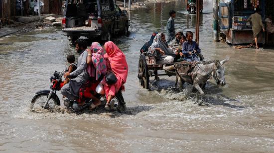 Personas transitan por una calle inundada de Jacobabad, en Pakistán, el 30 de agosto de 2022. 