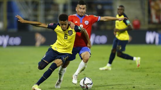 El defensor ecuatoriano Byron Castillo cubre una pelota ante el chileno Jean Meneses, el 16 de noviembre de 2021.