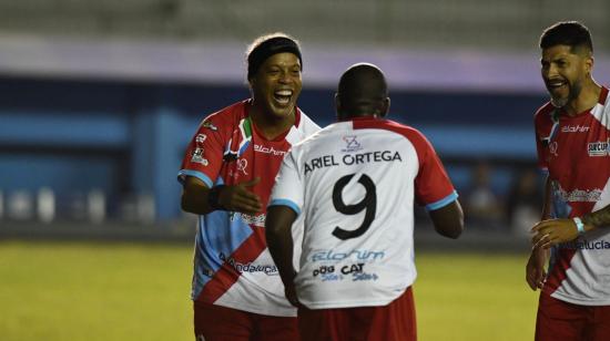 El exfutbolista brasileño Ronaldinho Gaúcho (i) celebra tras anotar un gol durante un partido de exhibición en Manta.