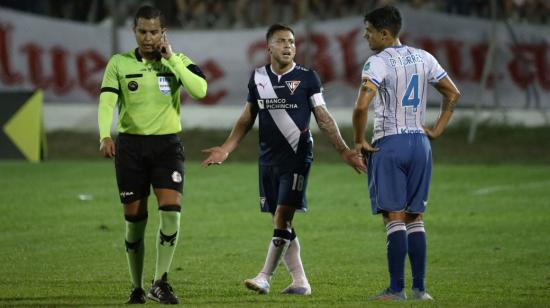 El árbitro Marlon Vera escucha a sus compañeros en el VAR durante el partido entre Liga y 9 de Octubre, en Milagro, el 1 de octubre de 2022.