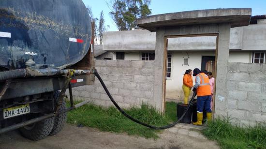 Un tanquero de la empresa de agua potable de Antonio Ante entrega el líquido en una vivienda del cantón, el 13 de marzo de 2022. 