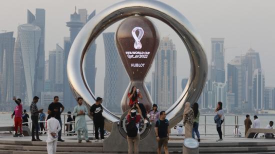 Aficionados se toman fotos junto al reloj que marca la cuenta regresiva para el inicio del Mundial de Qatar 2022.