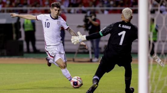 Keylor Navas (d) de Costa Rica disputa un balón con Christian Pulisic de Estados Unidos en un partido de las Eliminatorias para el Mundial de Qatar 2022.