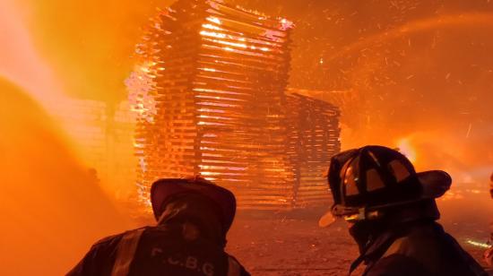 Los bomberos trabajaban en apagar las llamas del incendio en un galpón de madera en el Guasmo Norte, sur de Guayaquil, el 14 de noviembre de 2022.