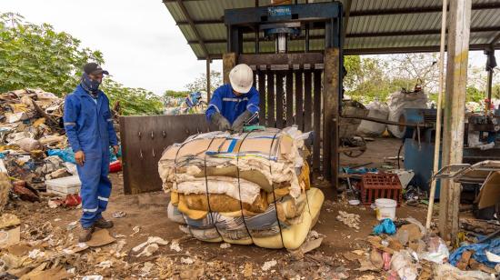 Dos trabajadores en Santa Cruz, Galápagos, durante el reciclaje de colchones. 