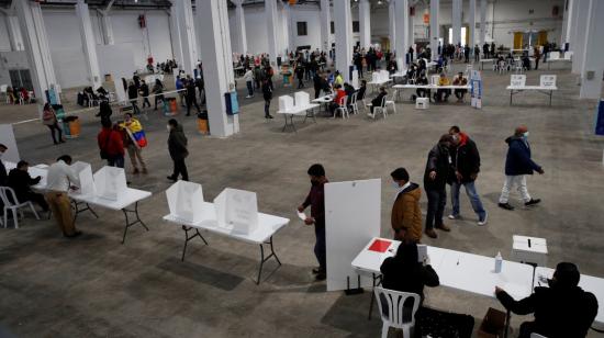 Ciudadanos ecuatorianos hacen cola en el recinto de la Fira de Barcelona, en España, para votar en la segunda vuelta de las elecciones presidenciales, el 11 de abril de 2021.