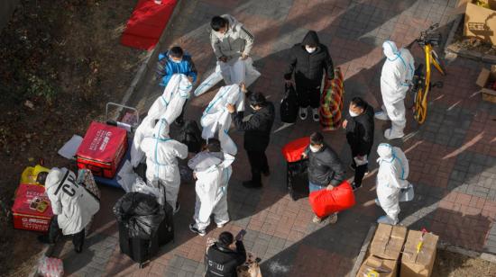 Trabajadores de salud voluntarios usan ropa protectora afuera de un edificio de la Unidad con un caso confirmado en Beijing, China, el 25 de noviembre de 2022.