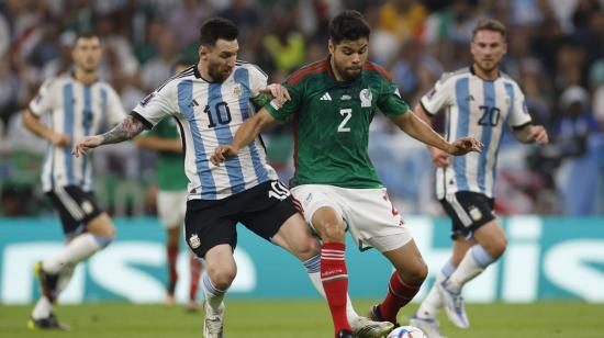 Lionel Messi disputa una pelota con el mexicano Nestor Araujo, en Lusail, el 26 de noviembre de 2022.